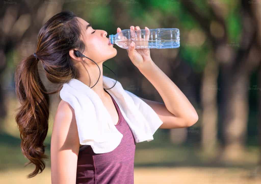 Hình ảnh người phụ nữ đang uống nước để phòng tránh nóng trong người
